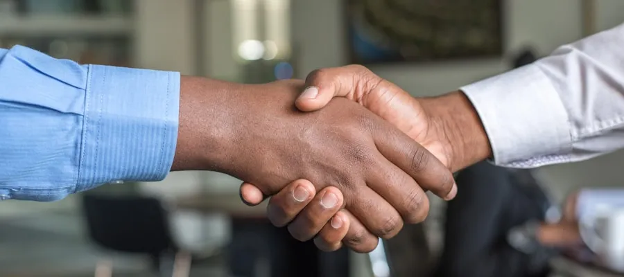 Handschlag zwischen Berater und Mandant nach erfolgreicher Zusammenarbeit
